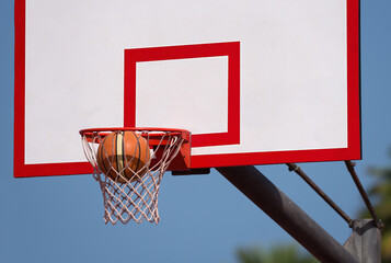 Good basketball throw. Basketball ball flies into a basketball hoop. Outdoor basketball court
