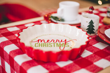decorative bowl in red and white with the inscription merry christmas focusing the camera on the inscription