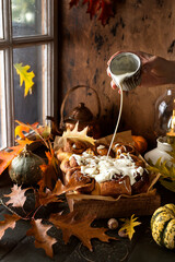 Pumpkin cinnamon rolls with buttery icingn with autumn decoration
