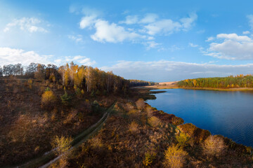 Aerial wide view of lake at sunrise in autumn. Meadows, orange grass, trees. Colorful landscape of river sunset. Horodok Ukraine