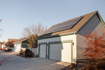 Detached gable of a three-car garage with solar panels on top of an asphalt shingle roof
