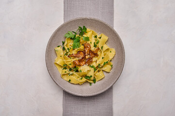 Homemade Italian pasta pappardelle with mushrooms chanterelles, cheese and parsley on plate with...