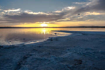 Fototapeta premium The Salinas of Torrevieja at sunset, a lagoon that produces salt by evaporation and is pink in color due to the microorganisms that inhabit it