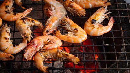 Fresh shrimp on a grill, under fire from charcoal. Grilled Seafood Grilled shrimp on a charcoal stove