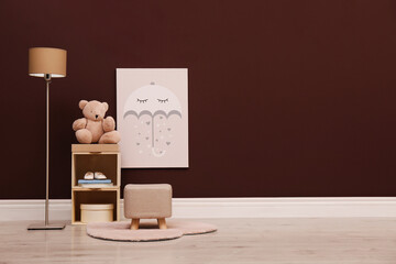 Stylish beige ottoman, shelving unit with toy bear and lamp in room. Space for text