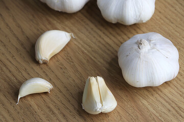 Garlic on chopping block on vintage wooden background.