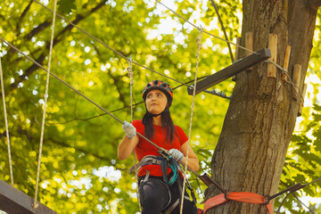 The young female instructor checks outfit in the rope park