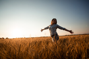 Woman with long hair in field at sunset