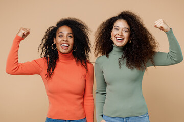 Two fitness sporty young curly black women friends 20s wear casual shirt clothes showing biceps...