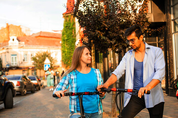 The loving couple ride an electric scooters and look at each other