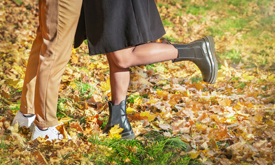 Legs (feet) of couple (man and woman) in love on natural autumnal background.  Fashion trendy style. .Love, friendship concept. Selective focus.