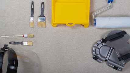 A set of tools for painting walls with paint. Brushes, tray, roller on the concrete floor