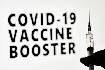 Fototapeta na wymiar Covid-19 Vaccine booster dose. Hand of the doctor holds a syringe with new Covid vaccine booster dose