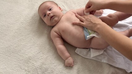 infancy, childhood, motherhood, hygiene, medicine health -mother changing baby diaper at home caring for happy newborn infant loving mom cleaning childs nappy moisturizing skin enjoying childcare