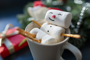 christmas, winter holidays and leisure concept - close up of marshmallow snowman taking bath in cup...