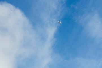 
Avión blanco volando sobre el cielo azul y las nubes

