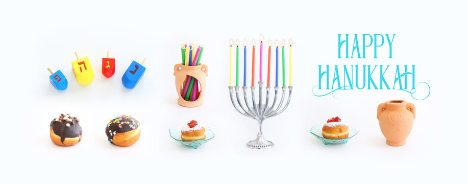 Religion image of jewish holiday Hanukkah background with menorah (traditional candelabra), doughnut and candles over white background
