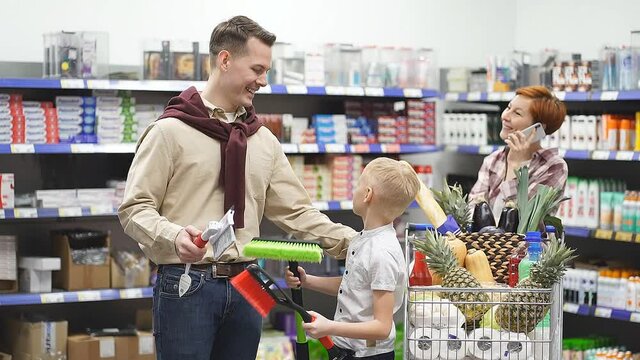 Family in the supermarket chooses a brush for the car.