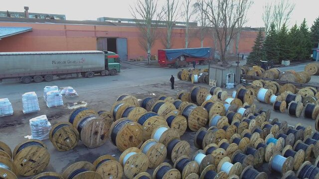 Span over coils with babin cable, large babin with wire under the open sky. Warehouse near the cable factory