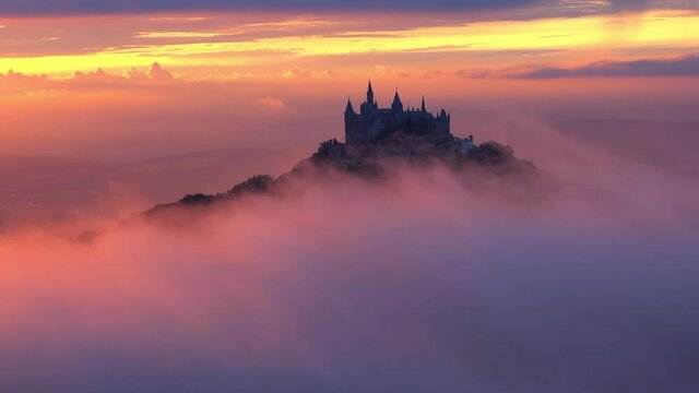 Aerial: Lockdown Idyllic View Of Hohenzollern Castle On Rock Formation During Sunset, Drone Flying Over Dramatic Clouds