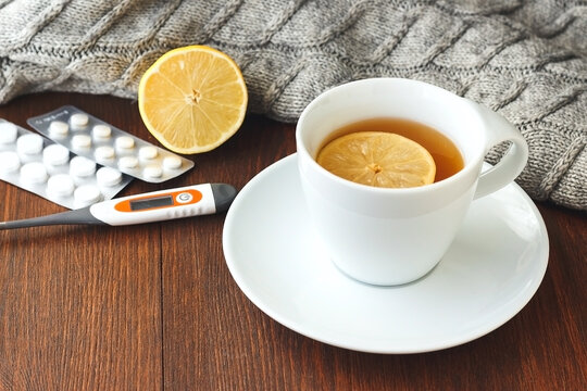 Hot drink with thermometer and pills. Concept - prevention of colds and flu, patient care.