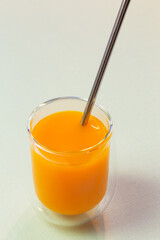 Natural vegetable fresh juice orange pumpkin carrot citrus in a glass glass with a straw. Healthy food