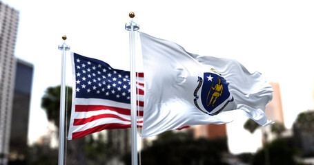 the flag of the US state of Massachusetts waving in the wind with the American flag blurred in the...
