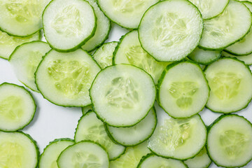 Slices of fresh cucumber pattern on white background, top view.