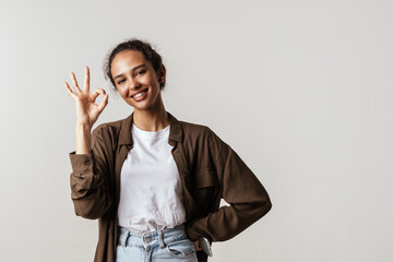 Young hispanic woman smiling and gesturing at camera