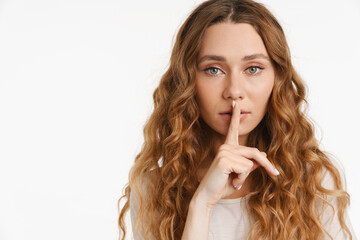 Young ginger woman wearing t-shirt showing silence gesture