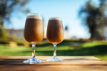 Ice coffee in two glasses in a park, for chilling and refreshment on a perfect sunny day