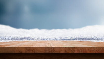 A festive winter Christmas wood table product display with a cold blue background.