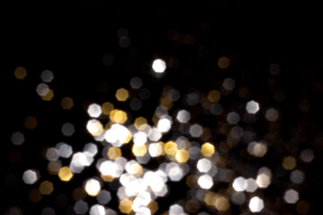 Golden and silver blurred bokeh lights on black background. Glitter sparkle stars for celebrate. Overlay for your design