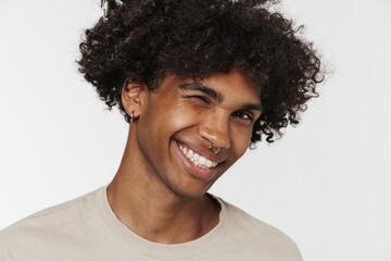 Fototapeta na wymiar Young black man with piercing smiling and winking at camera