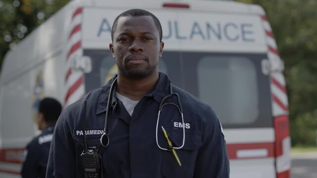 Portrait of african american paramedic in uniform standing outdoors