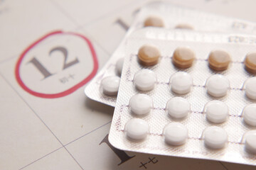 Fototapeta na wymiar birth control pills , calendar on table close up 
