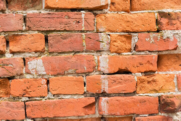 Fragment of the red brick wall of old abandoned building