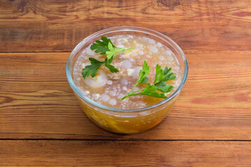 Pork jelly in the glass bowl on the rustic table