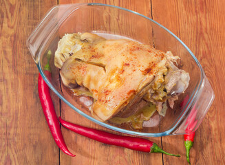 Baked ham hock in glass pan on old rustic table