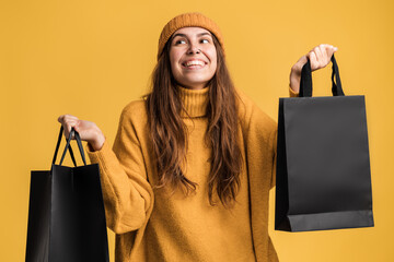 Portrait of overjoyed enthusiastic woman raising shopping bags, feeling great with packages and celebrating low prices. Black Friday concept. Studio shot, commercial of fashion store