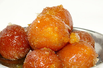 close up of indian dessert or sweet gulab jamun in a glass bowl isolated on white background.