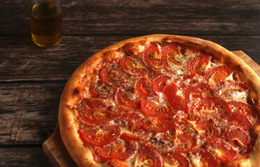 margarita pizza with tomatoes, cheese, spices and olive oil on a dark background