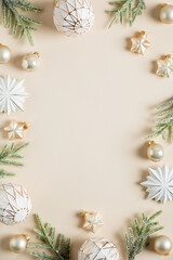 Vertical Christmas banner design. Boho style Christmas balls, stars decoration and fir branches on beige background. Flat lay, top view, copy space
