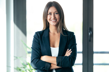 Beautiful young business woman standing while smiling looking at camera in the office.