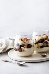 tiramisu dessert in a glass on a light background