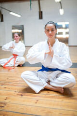Fototapeta premium Focused young Caucasian karatekas ready for class in karate pose. Group of female practitioners prepared for karate lesson. Sports, martial arts, healthy lifestyle concept