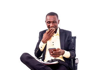 businessman sitting on a chair and using a mobile phone smiling.