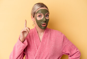 Young caucasian woman wearing face mask isolated on yellow background having an idea, inspiration concept.