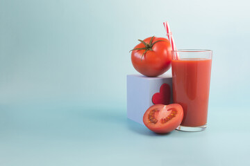 The concept of a positive attitude to tomato juice. Tomato juice, tomatoes and a red heart on a blue background