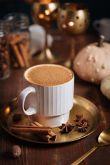 A cup of pumpkin spice latte or salep in a rustic wooden autumn atmosphere